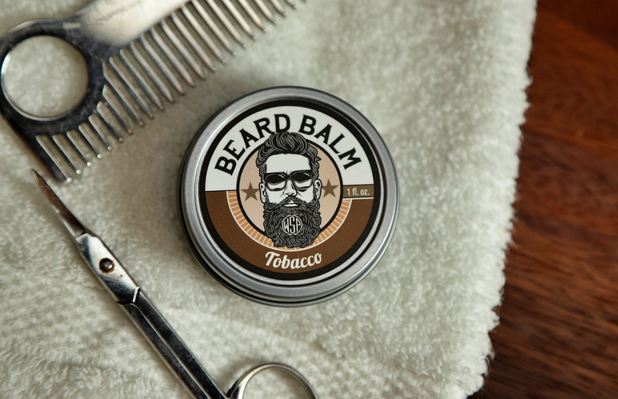 WSP Beard Balm Black Tobacco on towel with scissors and comb