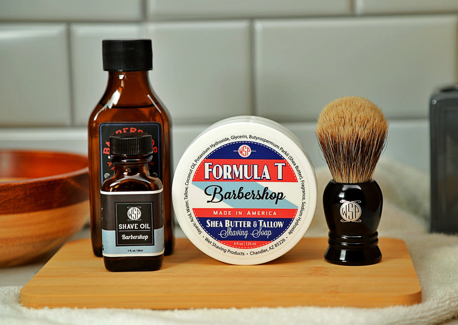 WSP Shaving Set of Barbershop shave oil, rustic shaving soap, aftershave tonic and shaving brush all sitting on wooden board with white towel