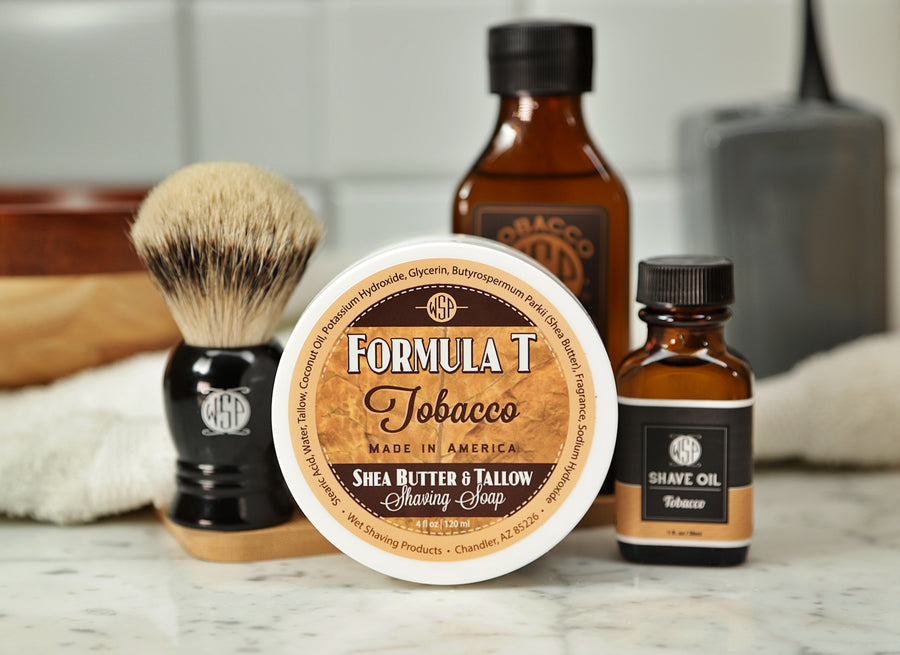 Shaving Set of Tobacco shave oil, Formula T shaving soap, aftershave tonic and shaving brush all sitting on wooden board with white towel
