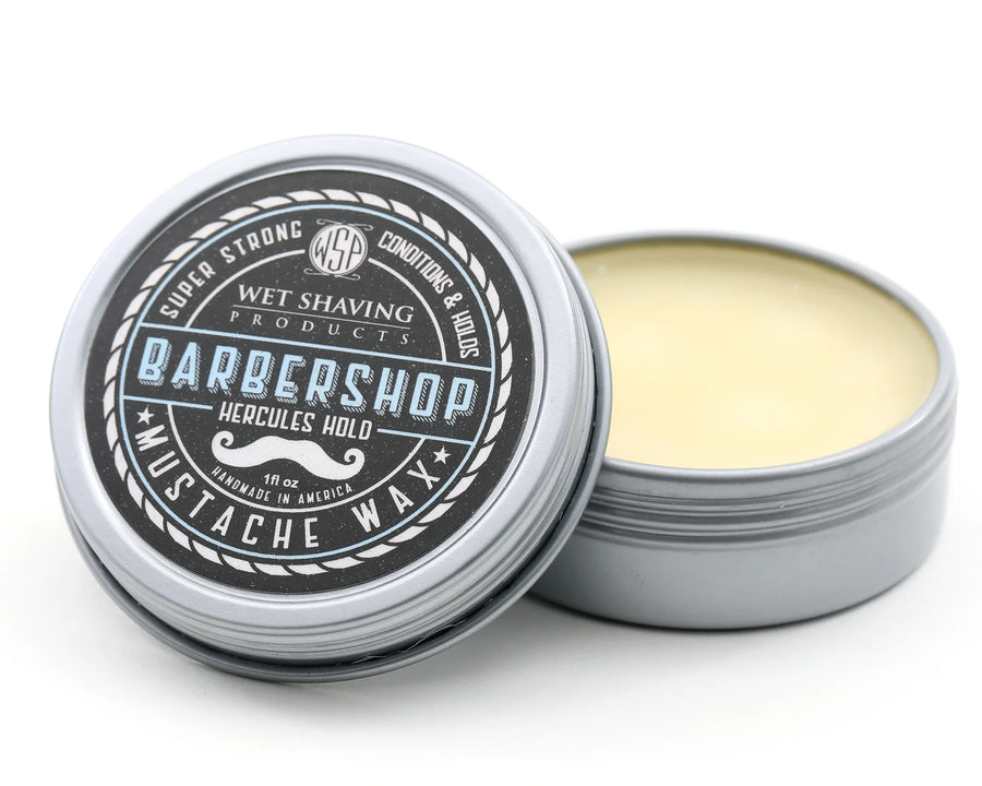Open Hercules Hold Mustache Wax tin with 'Barbershop' scent, lid leaning against the base.