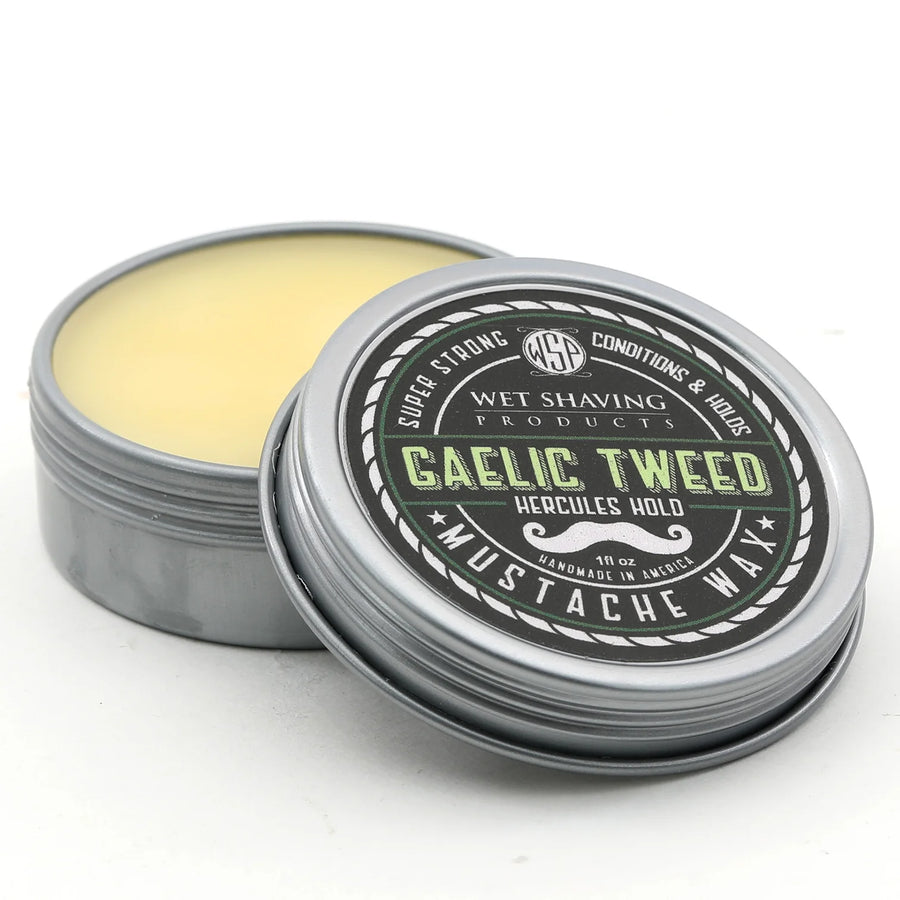 Open Hercules Hold Mustache Wax tin with 'Gaelic Tweed' scent, lid leaning against the base.
