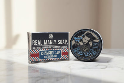 Barber shop products including a shampoo bar and hair paste on a white background