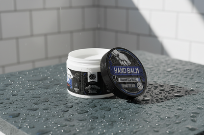 hand balm Resting on a cool dark grey slate tile surface covered in fresh water droplets and cold condensation, bright high-contrast daylight casting sharp shadows, out of focus background of a clean white tiled shower wall or pool area, refreshing, energetic atmosphere, photorealistic render, 8k resolution.