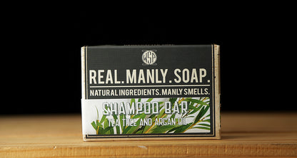 WSP Shampoo Bar in Tea Tree and Argan Oil scent sitting on a  wooden table