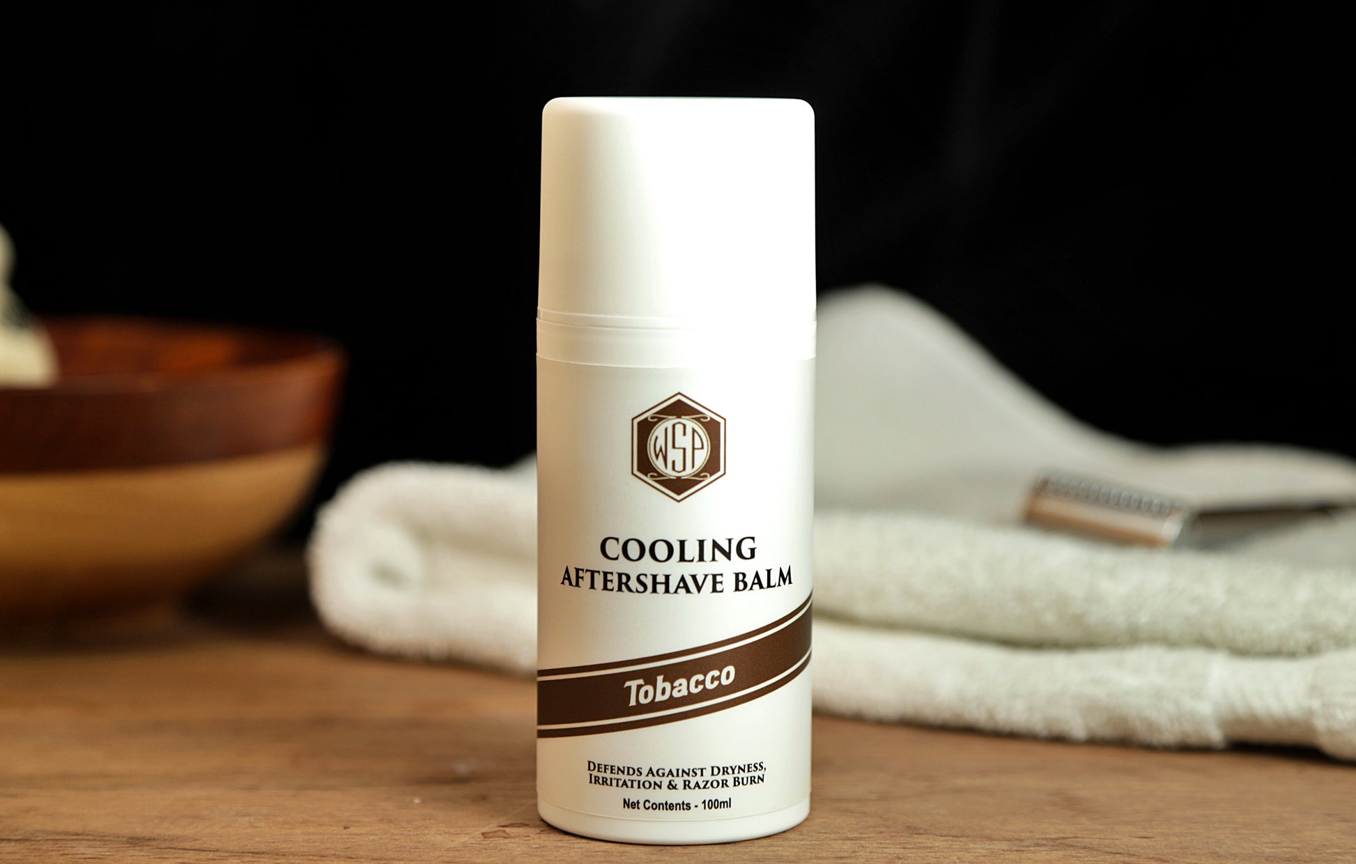Small white bottle on table WSP Cooling Aftershave Balm in Tobacco scent
