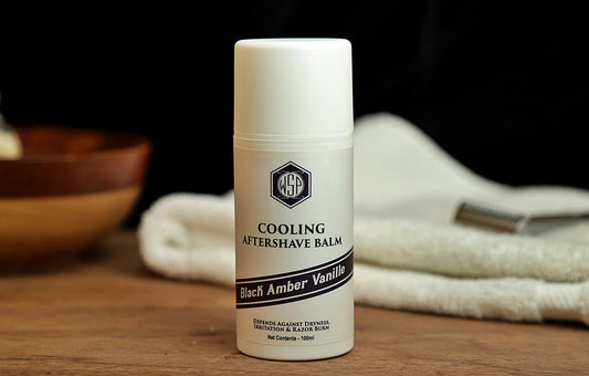 Small white bottle on table WSP Cooling Aftershave Balm in Black Amber vanilla scent