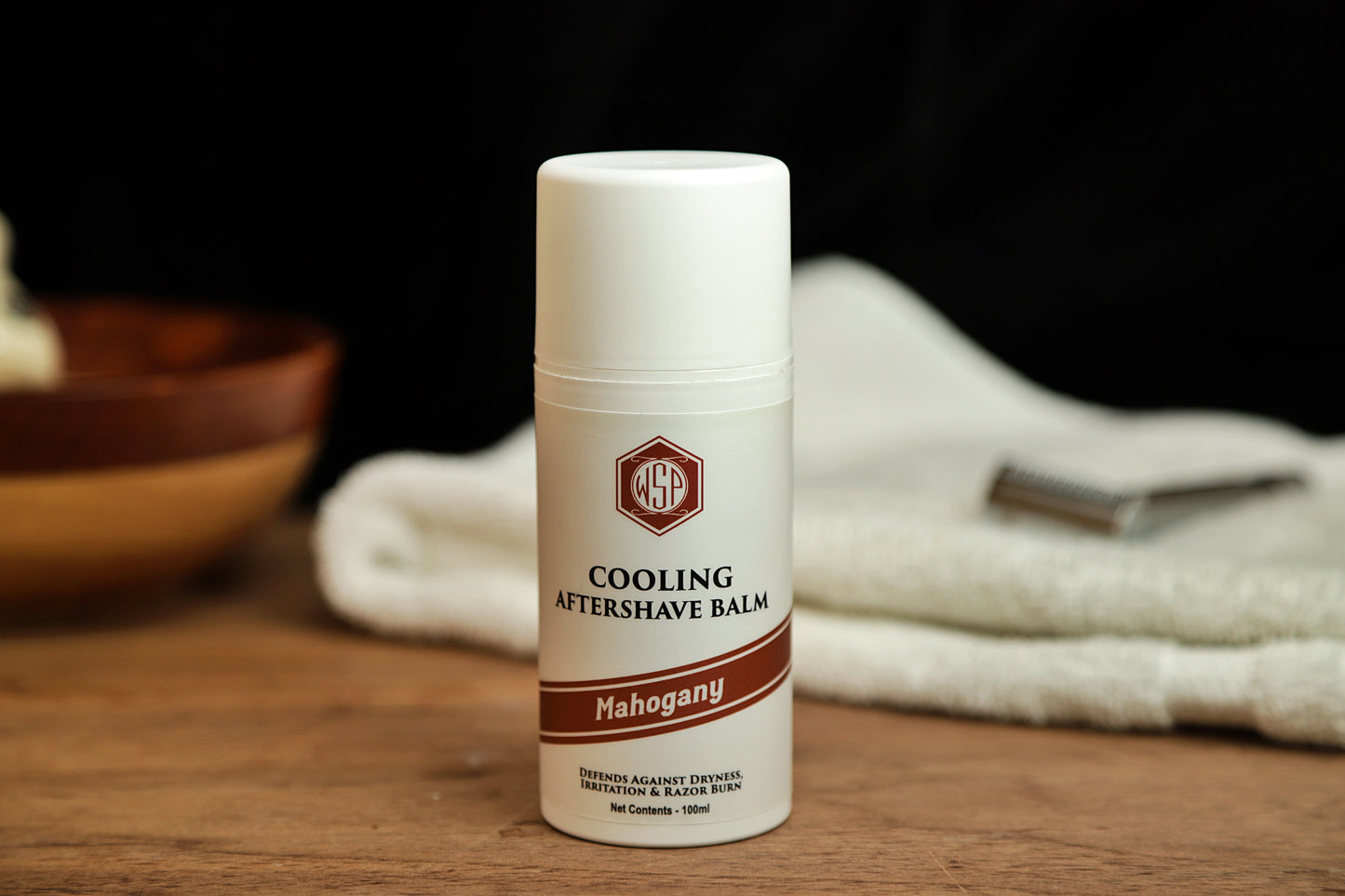 Small white bottle on table WSP Cooling Aftershave Balm in Mahogany scent