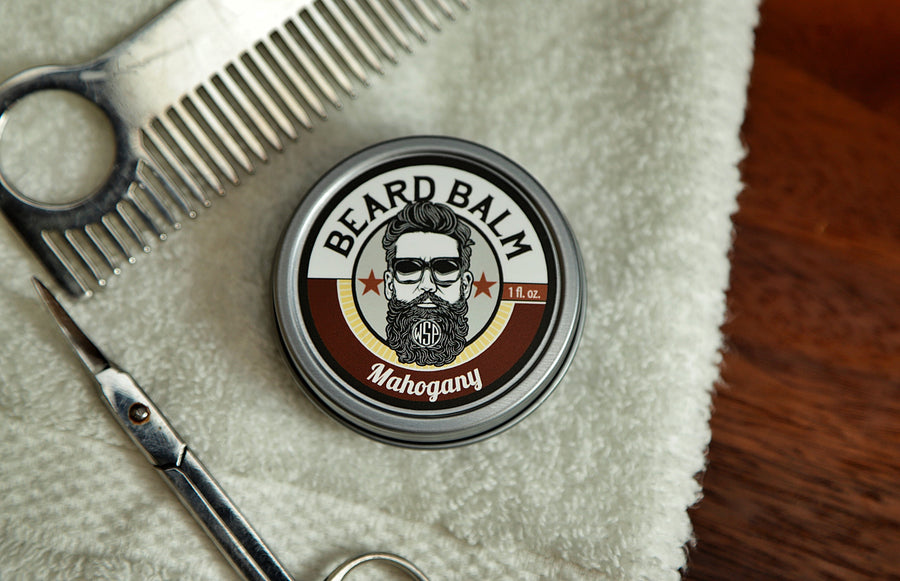 WSP Beard Balm in Mahogany on towel with scissors and comb