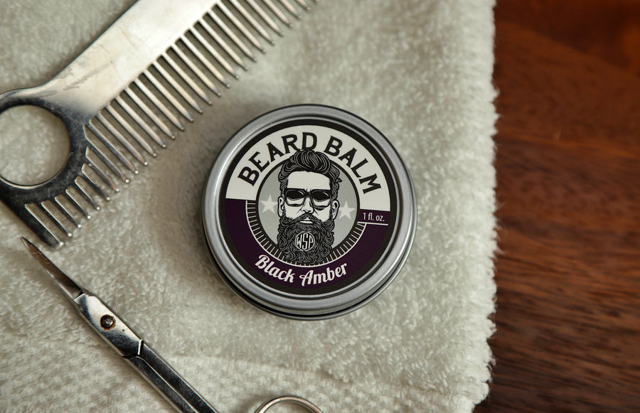 WSP Beard Balm Black Amber on towel with scissors and comb