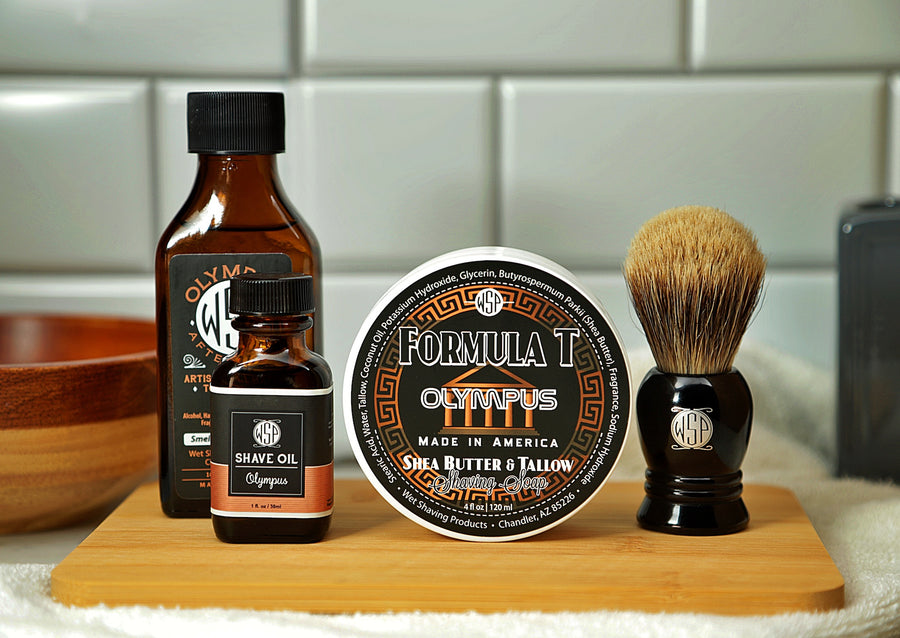 WSP Shaving Set of Olympus shave oil, rustic shaving soap, aftershave tonic and shaving brush all sitting on wooden board with white towel