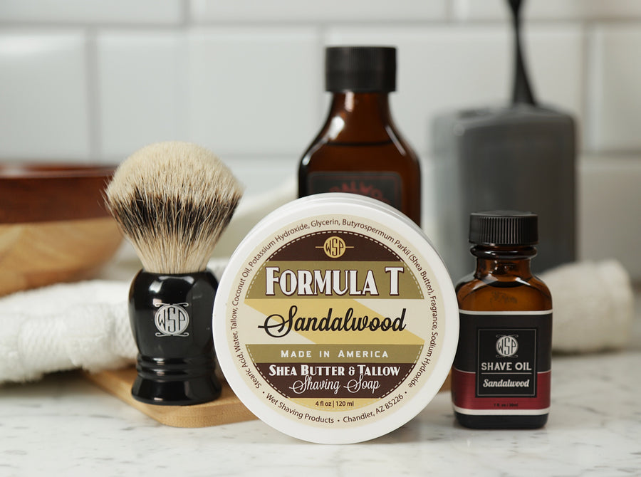 Shaving Set of Sandalwood shave oil, Formula T shaving soap, aftershave tonic and shaving brush all sitting on wooden board with white towel