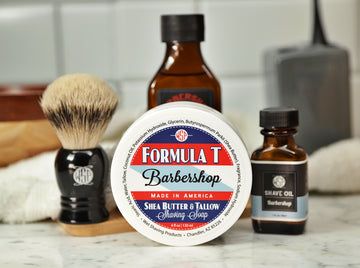 Shaving Set of Barbershop shave oil, Formula T shaving soap, aftershave tonic and shaving brush all sitting on wooden board with white towel