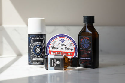 Collection of barbershop products including aftershave, soap, and oil on a white background
