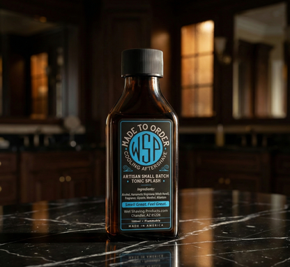 The Reserve Collection Cooling Aftershave Splash Sitting on a polished black marble surface with faint white veining, dramatic side lighting creating a chiaroscuro effect, dark blurred background suggesting a high-end master bathroom or dressing room with hints of warm amber light, sleek, minimalist luxury, photorealistic, 8k resolution, deep depth of field.
