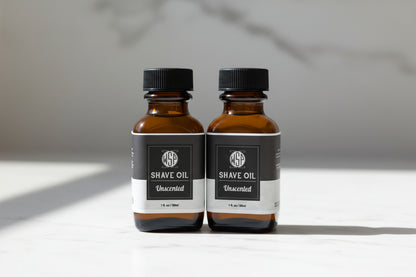 Two bottles of WSP Shave Oil on a white background