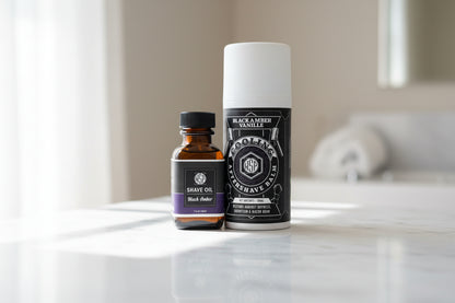 Two bottles of shaving products on a marble surface with a blurred background