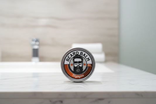 Beard balm container with label featuring a beard illustration on a textured surface.