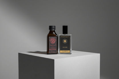 Two bottles of wet shaving products on a white platform with a gray background