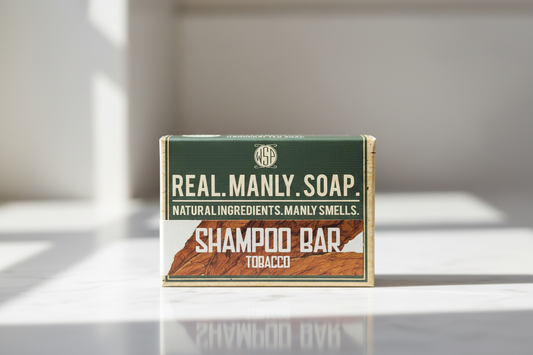 Real Manly Soap shampoo bar packaging on a reflective surface with a neutral background